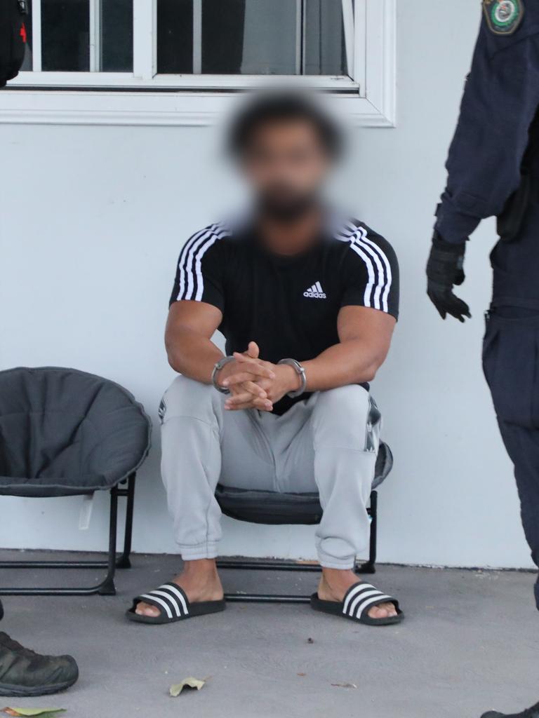 A man sitting outside a home in Guildford talks with police.