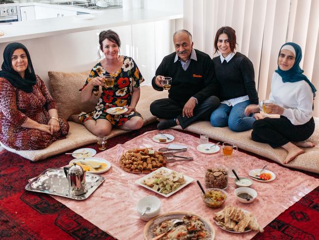 Karimullah Zarifi and his family enjoy a meal with celebrity cook Anna Gare. Picture: Tim Thatcher