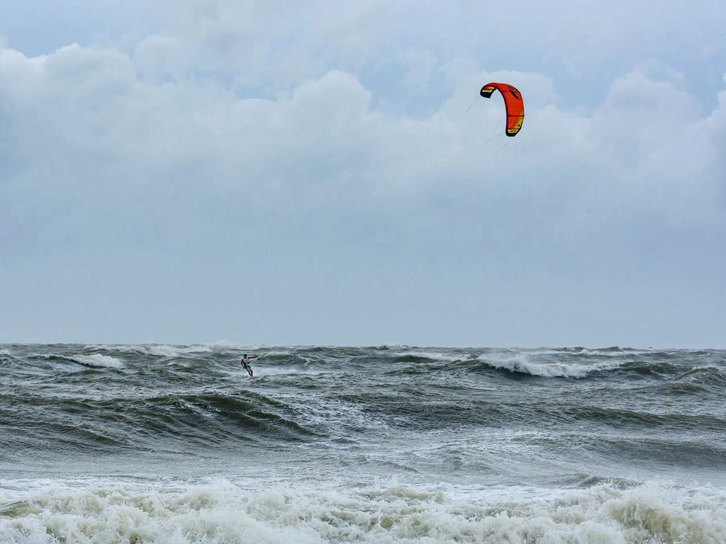 As Hurricane Dorian approaches Tybee Island, a kiteboarder takes advantage of the large waves generated by the storm. Picture: Casey Jones/Savannah Morning News via AP