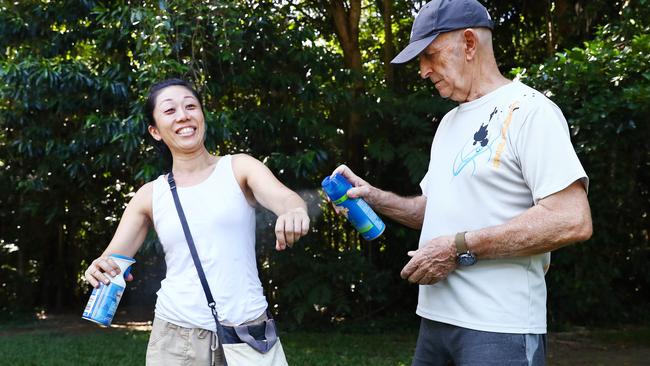 Swarms of mosquitoes have been breeding near Cairns creeks and rivers this week, attacking anyone not wearing long clothing or repellent. Shizuka and James Ward of Parramatta Park protect themselves from mosquito bites by spraying mozzie repellent before going for a walk along Freshwater Creek at Goomboora Park, Brinsmead. Picture: Brendan Radke