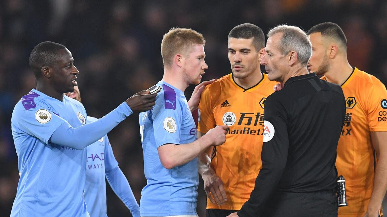 Manchester City's Benjamin Mendy (L) holds the flask thrown by Wolves fans.