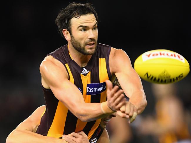 MELBOURNE, AUSTRALIA - JUNE 10: Jordan Lewis of the Hawks handballs whilst being tackled by Kyle Langford of the Bombers during the round 12 AFL match between the Essendon Bombers and the Hawthorn Hawks at Etihad Stadium on June 10, 2016 in Melbourne, Australia. (Photo by Quinn Rooney/Getty Images)