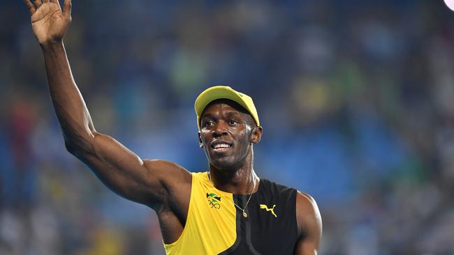 Usain Bolt of Jamaica waves to the crowd after winning the men's 100m final.