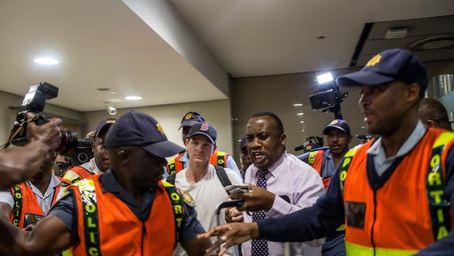 Former Australian captain Steve Smith is shuffled through the airport in Johannesburg. Picture: AFP