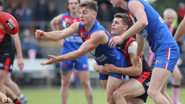 Harry Grant dishes out a handball under pressure from West Adelaide’s Michael Mattingly in Round 13. Picture: David Mariuz/SANFL