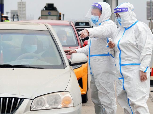 Medical staff directs a driver as they check people's nucleic acid test results in Yantai, in China's eastern Shandong province. Picture: AFP