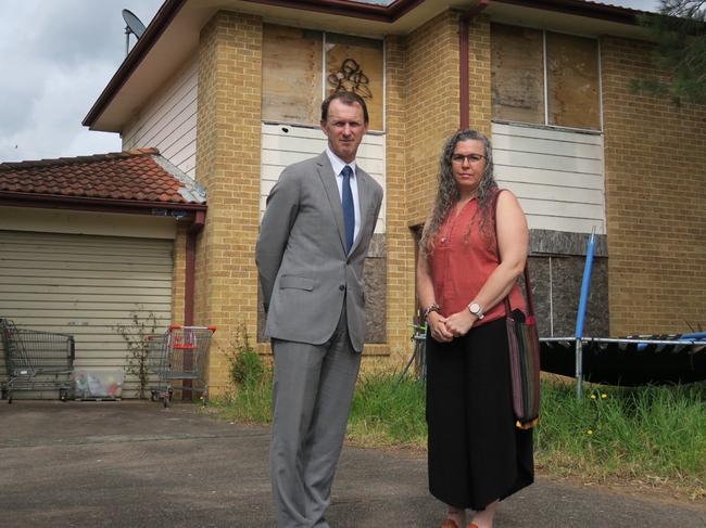 The Entrance State Labor MP David Mehan with Debbie, a mother of six children who has been on the priority waiting list for 12 months, as properties such as the duplex behind them at 5-7 Faye Close, Bateau Bay, sits vacant. Picture: Richard Noone