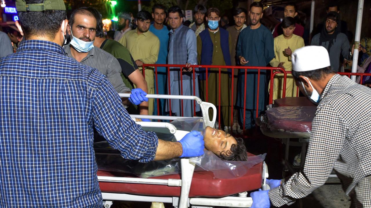 Volunteers and medical staff bring an injured man on a stretcher to a hospital for treatment after two powerful explosions outside the airport in Kabul. Picture: Wakil Kohsar/AFP