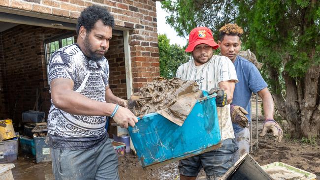 Leslie Rakwa, Solo Wala and Joseph Magalu help clear homes of flood-damaged items in Wingham. Picture: Thomas Lisson