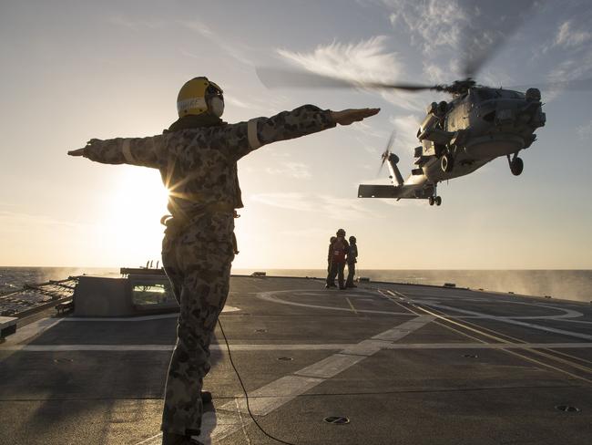 Leading Seaman Physical Trainer James Farquhar marshals the embarked MH-60R Seahawk over the flight deck of HMAS Parramatta during deck transfers. Picture: Defence