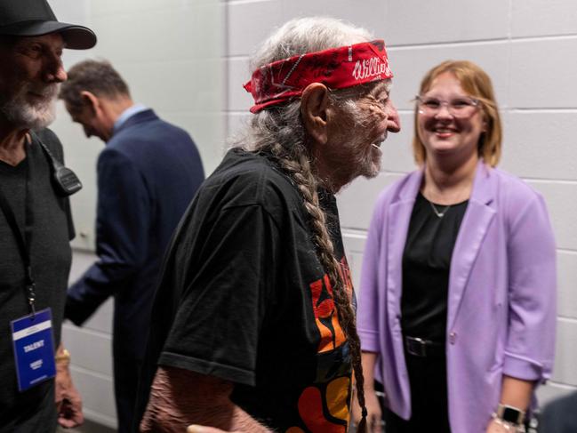 US Singer Willie Nelson greets well wishers lining up to greet US Vice President and Democratic presidential candidate Kamala Harris backstage, before she was due to speak during a campaign rally at Shell Energy Stadium in Houston, Texas, on October 25, 2024. (Photo by ROBERTO SCHMIDT / AFP)