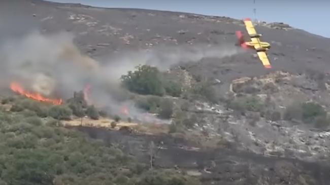 The plane, with two pilots from the Greek Defence Force on board, appears to clip a tree shortly after dropping a water bomb on the forest fire. Picture: Supplied