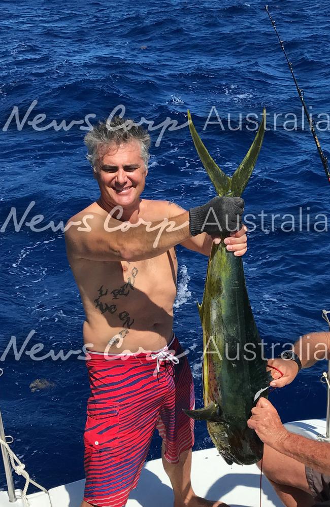 John Nikolic holding a large Mahi Mahi fish he caught while on the yacht. Picture: Jeff Hassell.