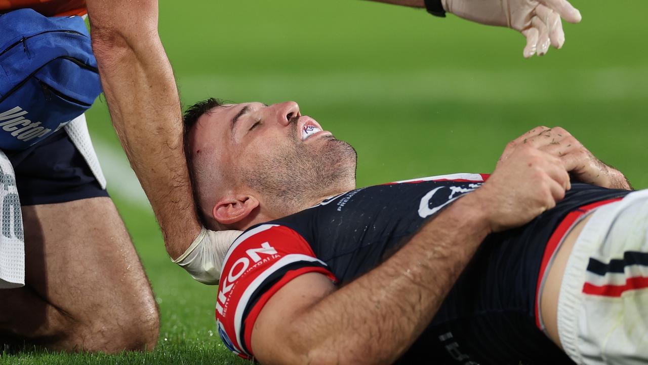 SYDNEY, AUSTRALIA - APRIL 05: James Tedesco of the Roosters is attended to by a trainer after an attempted tackle on Viliame Kikau of the Bulldogs during the round five NRL match between Canterbury Bulldogs and Sydney Roosters at Accor Stadium on April 05, 2024, in Sydney, Australia. (Photo by Cameron Spencer/Getty Images)