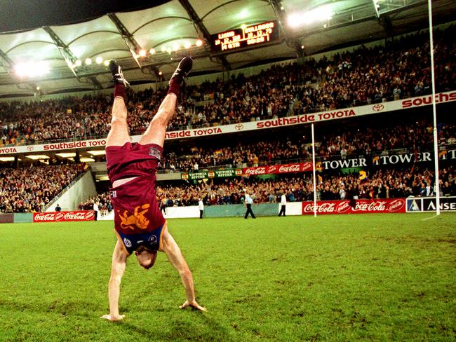 Jason Akermanis performs a handstand in front of the Gabba crowd.