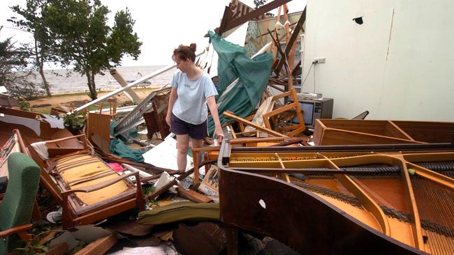 Toni Llewellyn checks her neighbour's home at Kurrimine Beach, south east of Innisfail following Cyclone Larry in 2006. The town was bracing for Yasi five years later.