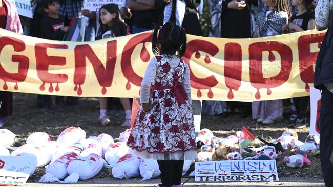 A girl with dolls wrapped in shrouds. Picture: NCA NewsWire / Martin Ollman