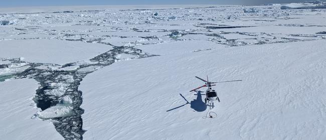 A helicopter lands on sea ice near Cape Denison in Antarctica. Picture: David Killick