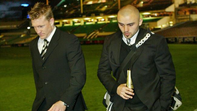 Shaw and Nathan Buckley leave the MCG after the 2003 Grand Final loss.