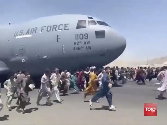 People run on tarmac of Kabul international airport as a US military aircraft attempts to take off in this screenshot from a video. Picture: TOLOnews