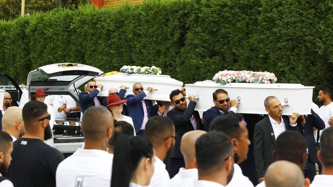 Mourners wearing white lined the driveway as the caskets were carried from the hearse. Picture: Matrix