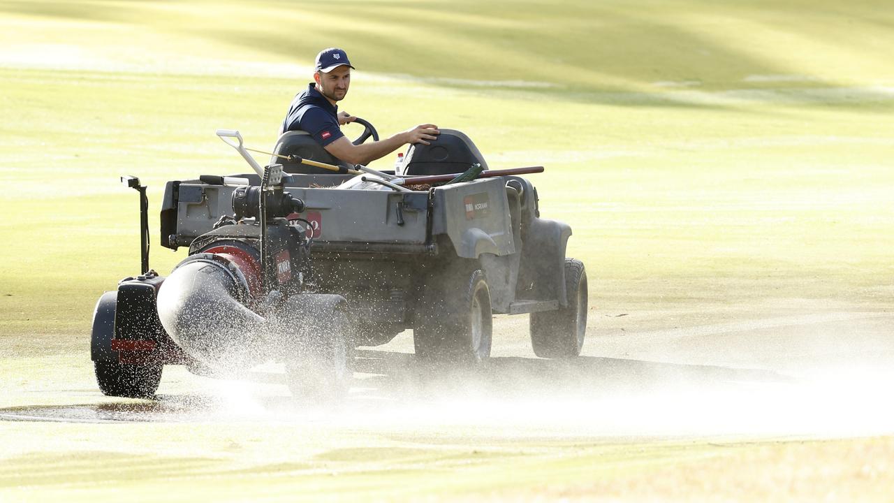 A groundskeeper pumps away excess water. (Photo by Darrian Traynor/Getty Images)