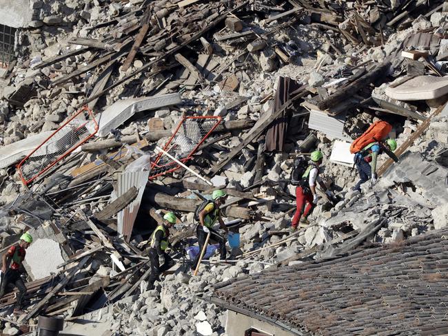 Rescuers make their way through destroyed houses following an earthquake in Pescara Del Tronto, central Italy. Picture: AP
