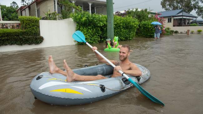 Residents paddle along floodwaters on the Sunshine Coast. Picture: Brad Fleet