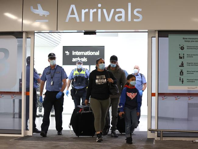 PERTH, AUSTRALIA - OCTOBER 19: Passengers from Qantas flight QF583 are escorted to waiting Transperth buses by Police Officers after being processed following their arrival at Perth Airport from Sydney, before being driven to a CBD hotel for quarantining on October 19, 2020 in Perth, Australia. The West Australian government is monitoring arrivals into Perth after 23 travellers from New Zealand flew into the state over the weekend despite Western Australia not being part of the Federal Government's travel bubble arrangement. The current one-way trans-Tasman bubble arrangement between New Zealand and Australia allows for travellers from New Zealand to travel to New South Wales or the Northern Territory without having to quarantine, however some travellers have then continued on to other states whose borders are not currently open to international arrivals. (Photo by Paul Kane/Getty Images)