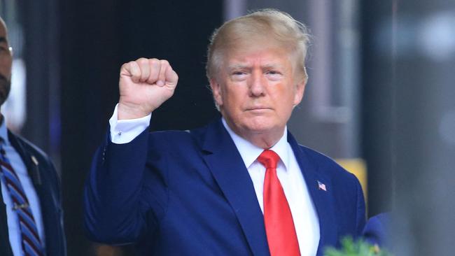 Former US President Donald Trump raises his fist while walking to a vehicle outside of Trump Tower in New York City (Photo by STRINGER / AFP)