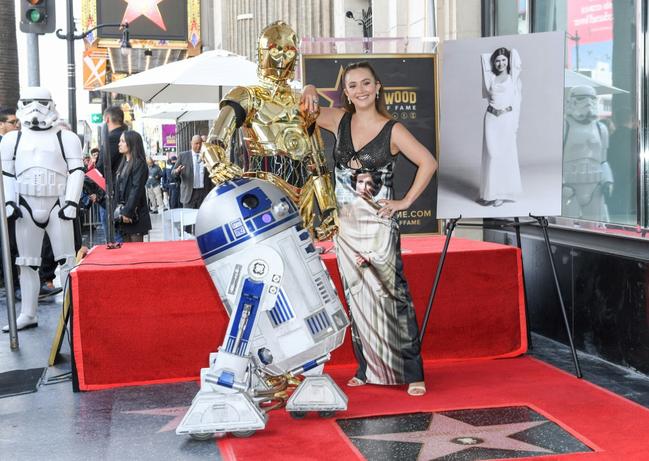Carrie Fisher's daughter Billie Lourd poses with 'Star Wars' character R2D2 and C3PO as her mother is honored posthumously with a Star on the Hollywood Walk of Fame