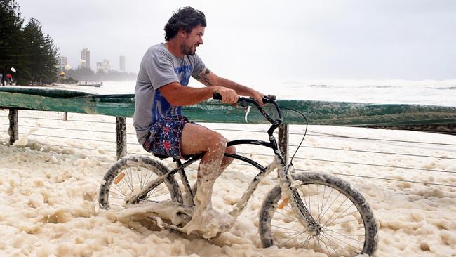 A Burleigh resident braved the wet weather to see the erosion. Picture: Adam Head