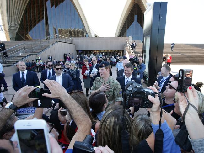 Prince Harry has a chat with the waiting media. Picture: Stephen Cooper