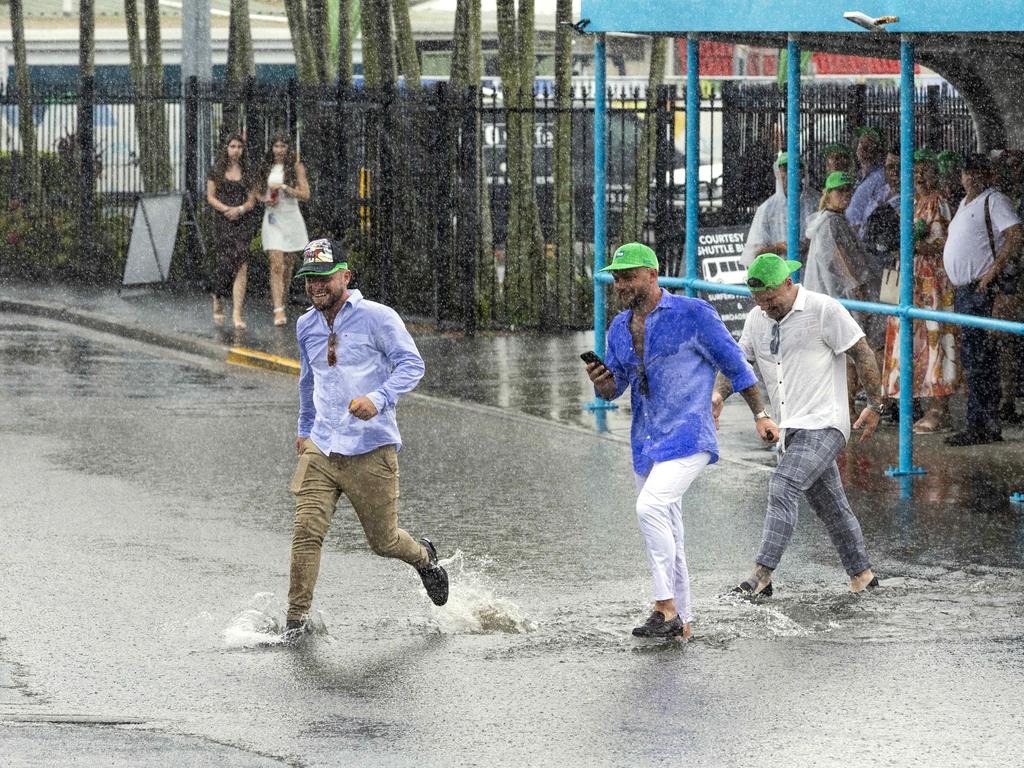 People leaving a wet Magic Millions Raceday at Gold Coast Turf Club. Picture: Richard Walker