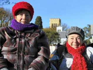 Marlene Pickard and Thelma Keogh set up chairs in the sun at yesterday’s markets to keep warm. Picture: Erin Smith