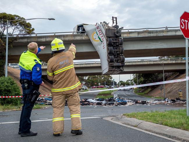 A police officer and a firefighter discuss the circumstances of the crash. Picture: Jake Nowakowski