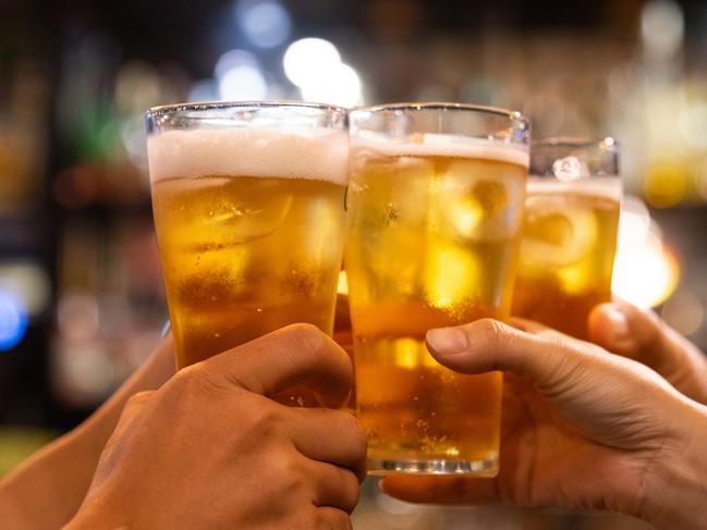 Group of happy friends drinking and toasting beer at brewery bar restaurant - Friendship concept with young people having fun together at cool vintage pub - Focus on middle pint glass