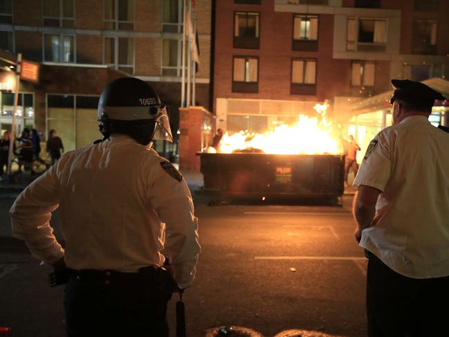 New York Police Department (NYPD) officers observe a dumpster fire in front of the Hampton Inn on west 35th street. Picture: Getty