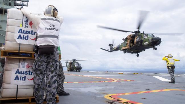 An Australian Army MRH-90 Taipan launches from the flight deck of HMAS Adelaide to drop disaster relief supplies to Nabouwalu on the island of Vanua Levu, Fiji, during Operation Fiji Assist. Picture: CPL Dustin Anderson/Defence