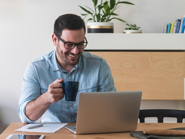 CAREERS: Happy young businessman using laptop and work from home