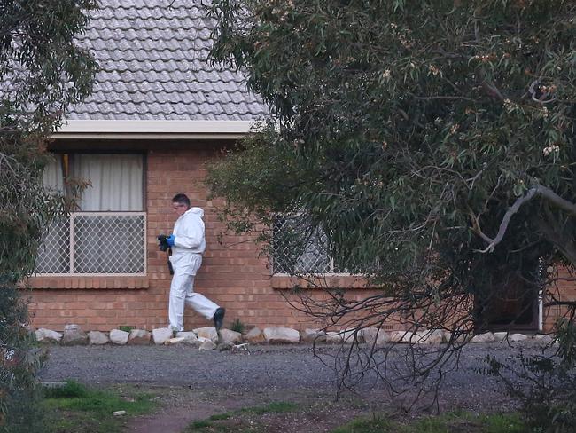 A crime-scene officer at the home in Hillier, in Adelaide’s north, where three bodies were found. Picture: Stephen Laffer