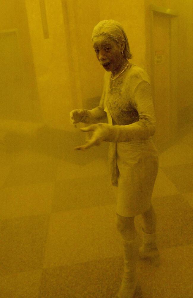 Marcy Borders is covered in dust as she takes refuge in an office building after one of the World Trade Centre towers collapsed in New York City. Ms Borders was caught outside on the street as the cloud of smoke and dust enveloped the area. Picture: Stan Honda/AFP