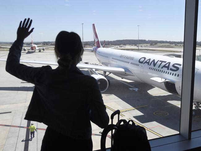 MELBOURNE, AUSTRALIA - NewsWire Photos NOVEMBER 22, 2021: A passenger farewells the first QANTAS international flight from Melbourne with a plane leaving for Singapore. Picture: NCA NewsWire / Andrew Henshaw