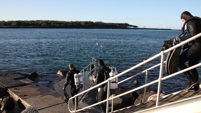 Police divers and friends of the deceased search the Southport Seaway for a weight belt that belonged to the diver that died. Picture Glenn Hampson