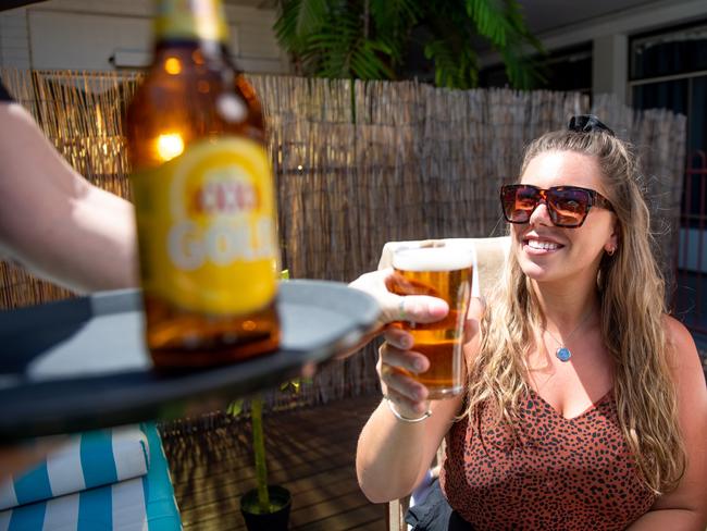 Lion, brewers of Queensland beer XXXX, will be shipping up thousands of litres of beer up to the NT in anticipation of pubs and bars reopening on May 15. Shelley Wilford from The Cav serves Danielle Jones a schooner by the Cav's pool.Picture: Che Chorley