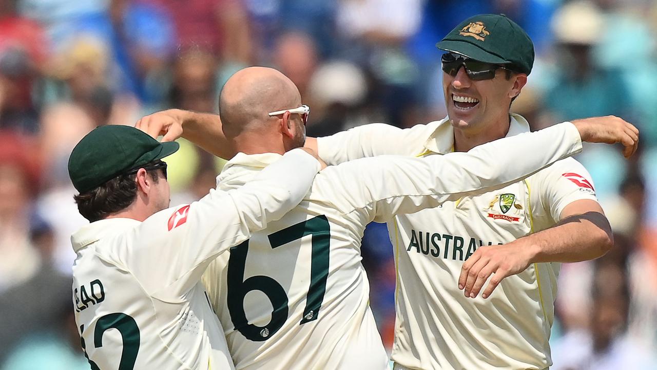 Pat Cummins celebrates the final wicket with Nathan Lyon and Travis Head. (Photo by Glyn KIRK / AFP)