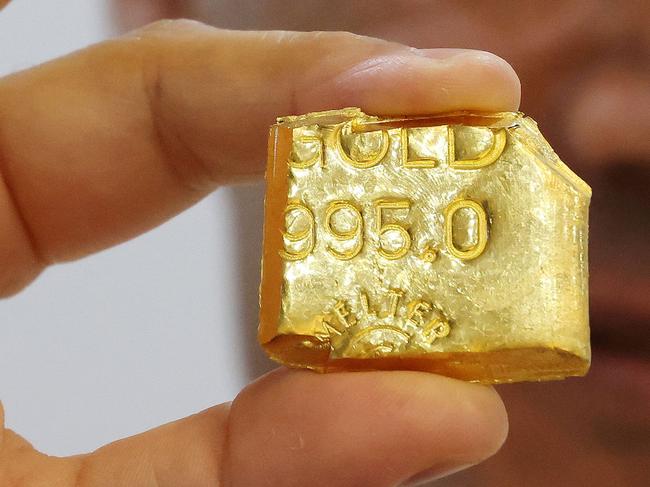 A jeweller displays a bar of gold at his shop in Kuwait City on October 21, 2024. (Photo by YASSER AL-ZAYYAT / AFP)