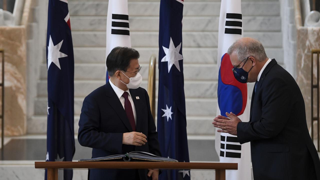 Prime Minister Scott Morrison welcomes South Korean President Moon Jae-in as he signs the official visitor’s book at Parliament House. Picture: Lukas Coch/Getty Images