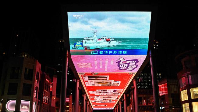 A public big screen broadcasts news about China's military drills around Taiwan, outside a shopping mall in Beijing. Picture: AFP