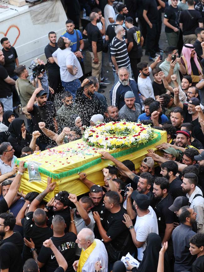 Mourners toss rice over the coffin of person a killed after hundreds of paging devices exploded in a deadly wave across Lebanon. Picture: AFP.